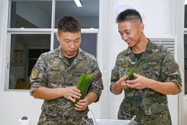武警官兵相互分享包粽子的方法。