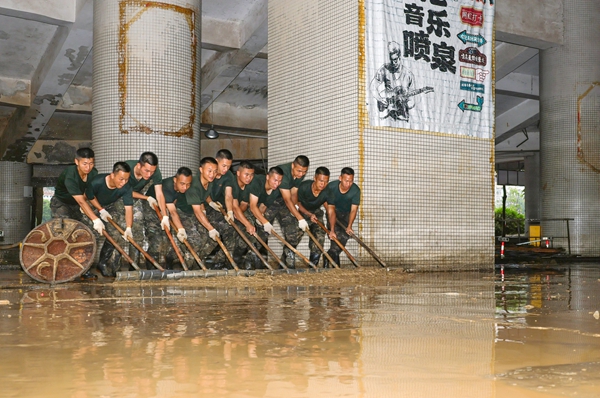 官兵协力清理淤泥。赖治华摄