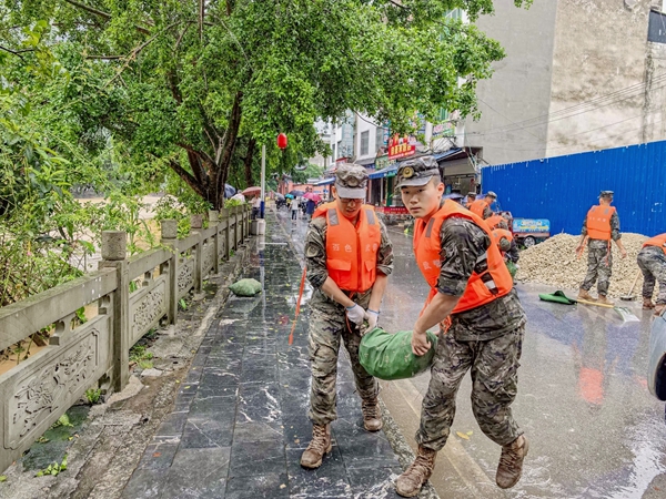 武警官兵正在搬运沙袋。