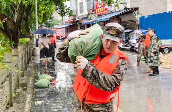 武警官兵正在搬运沙袋。