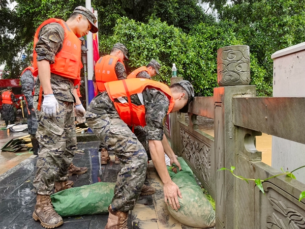 武警官兵正在加固河堤。