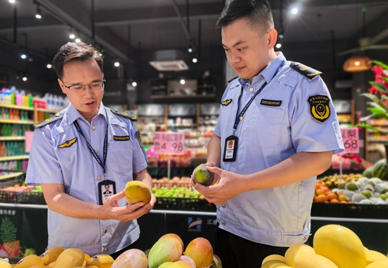南宁市市场监管局执法人员在横州市陶圩镇一家超市对时令水果进行检查。何正君摄