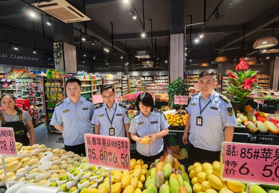 南宁市市场监管局执法人员在横州市陶圩镇一家超市对时令水果进行现场检查。何正君摄