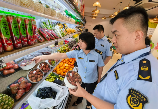 南宁市市场监管局执法人员在横州市一家水果经营门店进行检查。何正君摄