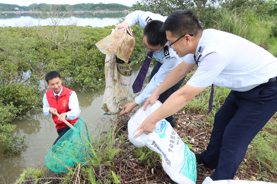 党员志愿者清理沿岸垃圾。熊舒静摄