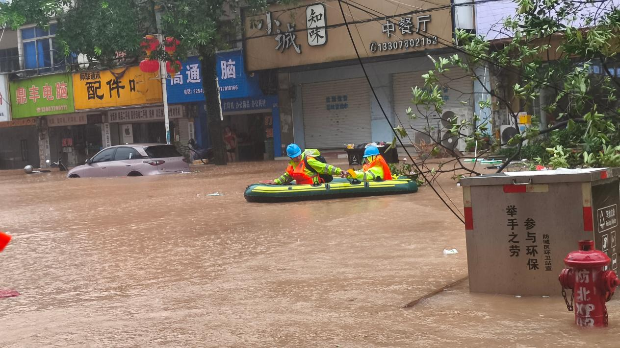 抢修人员乘坐皮筏艇雨中寻找故障点位。刘芳摄