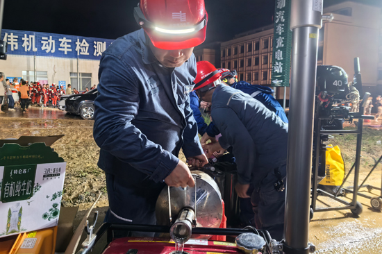 7月6日晚上，南方电网广西南宁横州供电局工作人员给照明灯添加油料。农秀凤摄