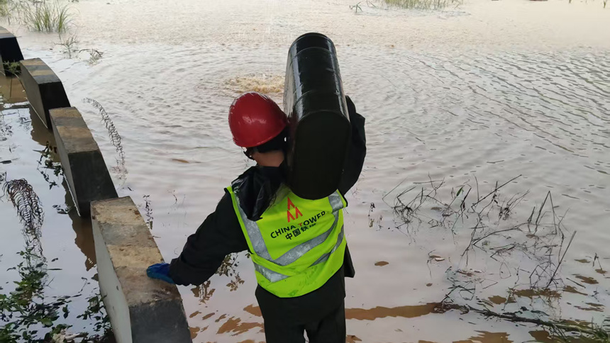 一線人員通過水淹路段前往基站進行發電保障作業。南寧鐵塔供圖