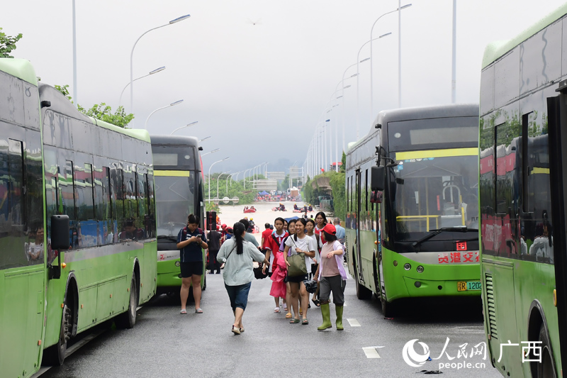 7月8日，貴港市獲救學生乘坐轉運車輛離開洪澇區域。人民網 龐惠文攝