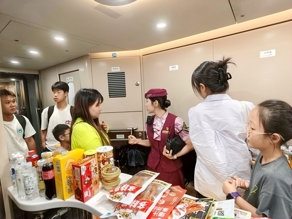 列车长黄玥在餐车跟旅客进行答疑解惑.黄斌立摄
