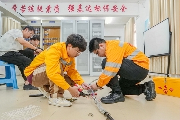 图为国铁南宁局柳州电务段姚长春（左）和郑屹峰（右）在实训基地接续信号电缆。苏韦摄