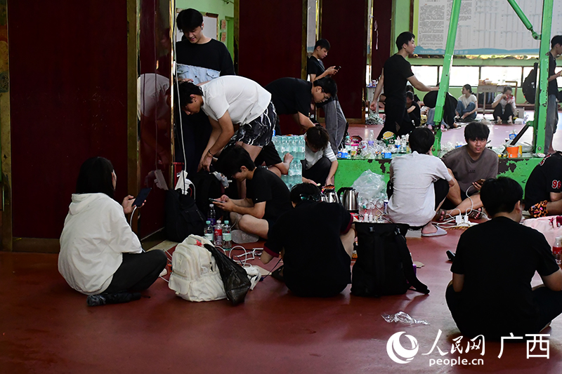 安置点内，学生们给手机充电。人民网 庞惠文摄