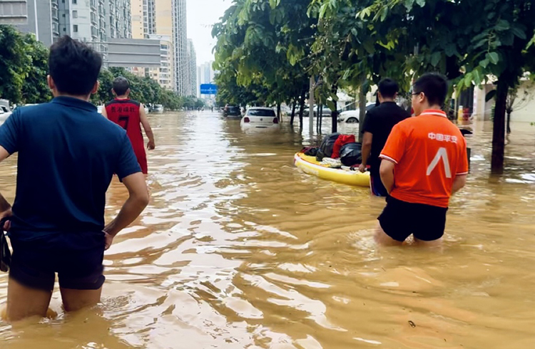 平安产险贵港中心支公司理赔员在深水中前行抵达办公点。平安产险广西分公司供图