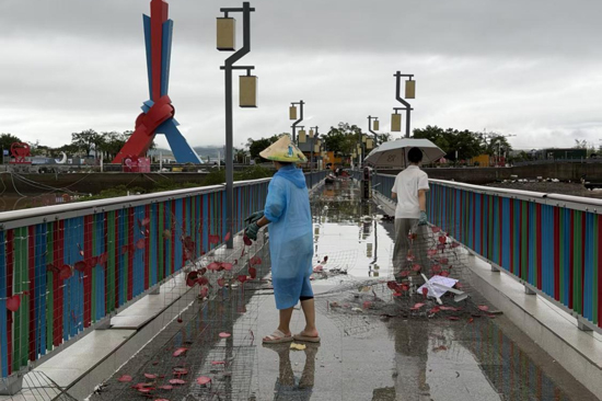 在中越界河風景區，廣旅東興邊海投資公司黨員清理廊橋上損毀的景觀設施。廣旅集團供圖