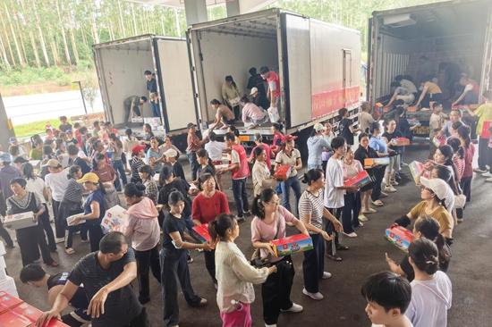 在横州市广西中肯茶叶有限公司赈灾物资卸货点，志愿者卸双汇火腿肠赈灾物资。（任海峰 摄）