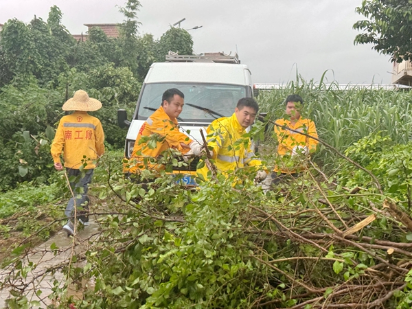 职工在乘坐工程车前往湘桂线水害点抢险的路上清理“拦路”倒树。黄海阳摄