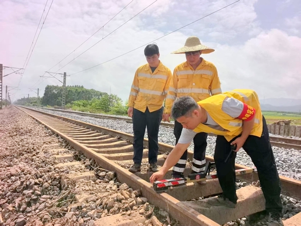 党员干部使用道尺测量黎湛铁路发生水害路段轨道几何尺寸。昌勇杰摄