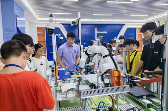 參觀工業機器人工作現場,體驗人工智能的科技感。學校供圖