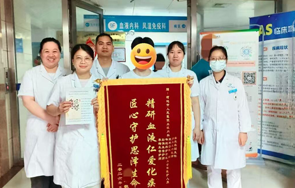 图为患者向河池市人民医院血液内科团队送锦旗