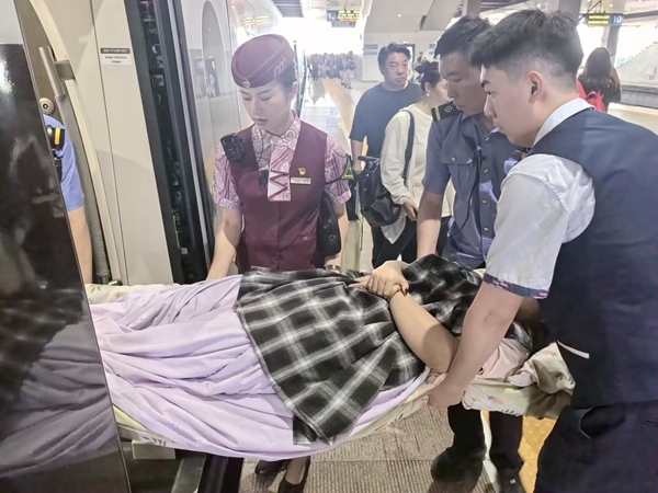 莫宇思协助将担架抬上列车。郝成利摄