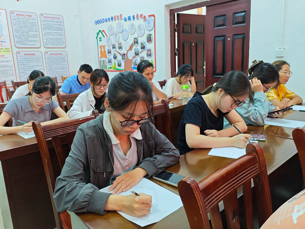 合诚社区妇女在学习手绘壮锦设计图。