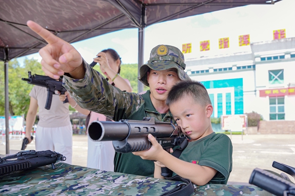 官兵教军娃瞄准。