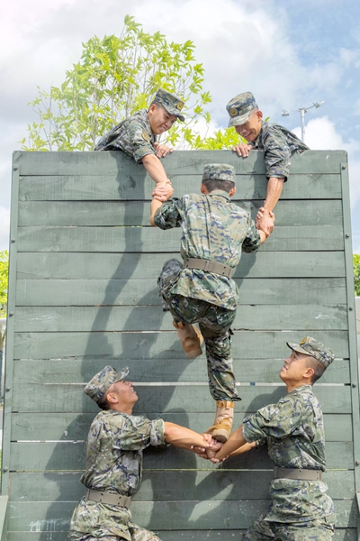 新兵们在进行协作攀登训练。