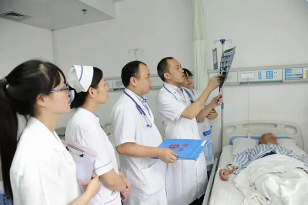 图为姚朝光带领团队查房，立足临床难题开展科研，多项成果获奖并推广应用。