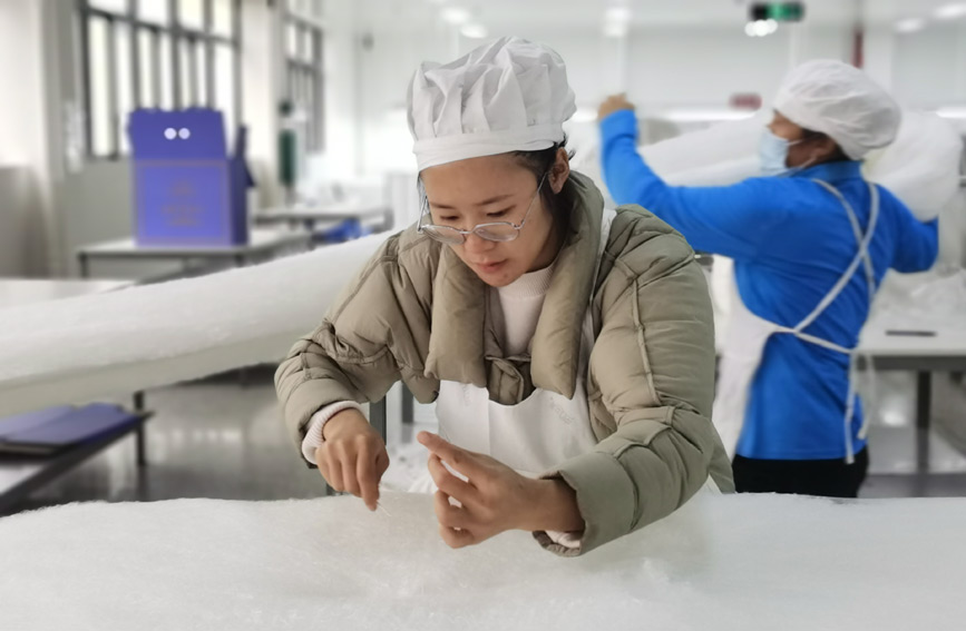 工人在制作蚕丝被。凌云县委宣传部供图