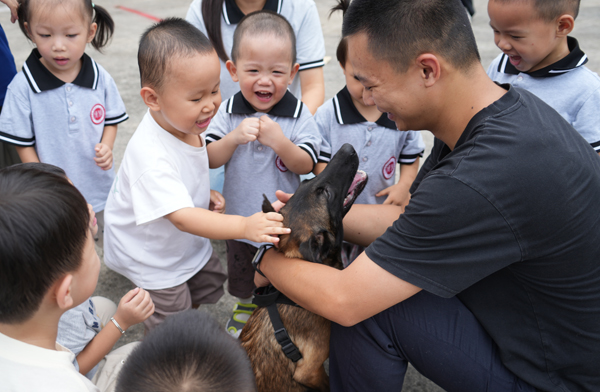 在训犬员安全引导下，小朋友们近距离和温顺的警犬友好接触