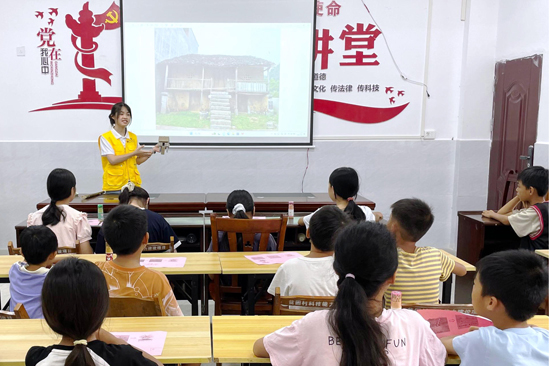 实践团成员讲述干栏式建筑并展示手工模型。学校供图