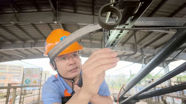 04羅盛孫在檢查機車受電弓滑條鋁脫架狀態。呂鬆洋攝