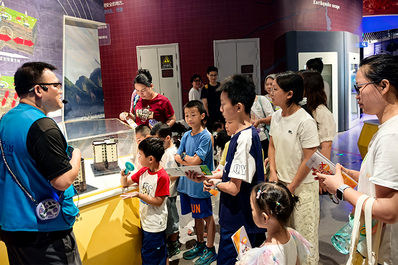 柳州市科技馆工作人员向观众讲解防震避险常识。自治区科协供图