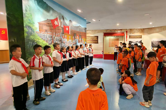红领巾宣讲员在红七红八军会师纪念馆为游客讲解红色历史。乐业县文旅局供图