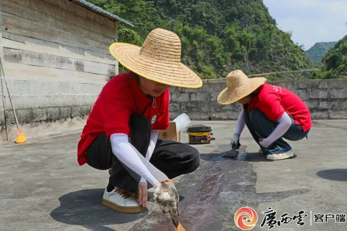 志愿者在裂缝处涂抹防水涂料。