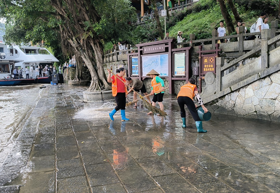 县环卫工人全面冲洗汛后码头积淤淤泥。