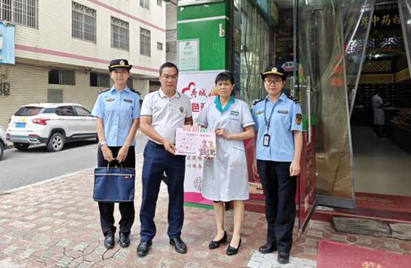 贵港市港南区市场监管局工作人员为暖“新”商户（俏妮大药房）授牌。