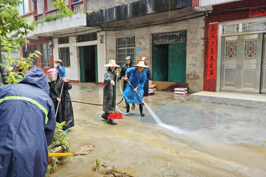 凭祥市党员干部手持水枪在华侨小区开展清淤工作