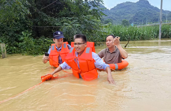 马医生（前）在民辅警和村干部的护送下脱离险境