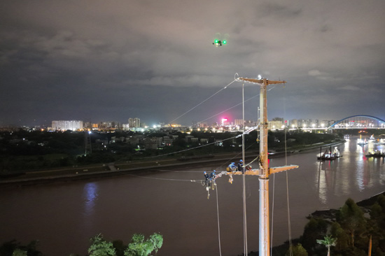 南方電網廣西欽州供電局組織電力施工人員有意避開白天用電負荷高峰時段,對跨平陸運河110千伏線路開展遷改工作。翟晉升攝