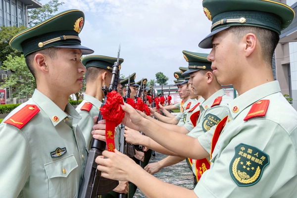 满服役期老兵为新兵整理红花。
