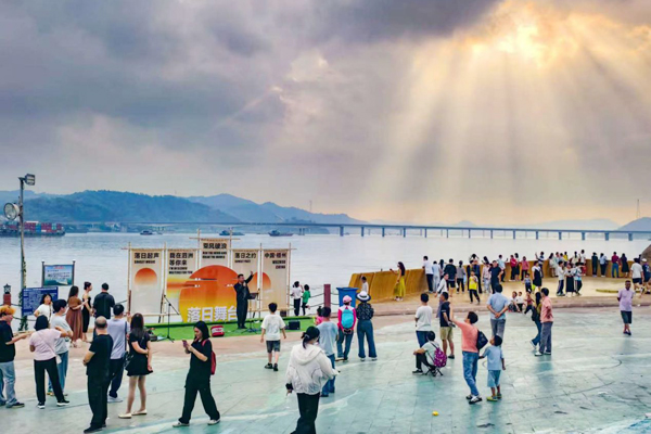在泗洲島洲頭,落日派對中,歌手在夕陽的沐浴下為游客演唱(資料圖)。蒙敏瑩攝