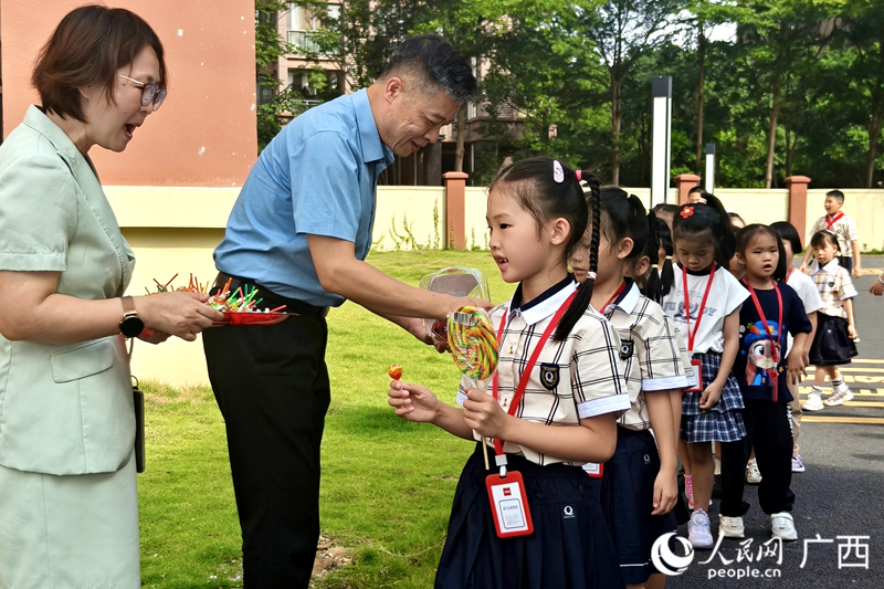 校领导与交警一同为孩子们分发糖果。人民网记者 陈燕摄