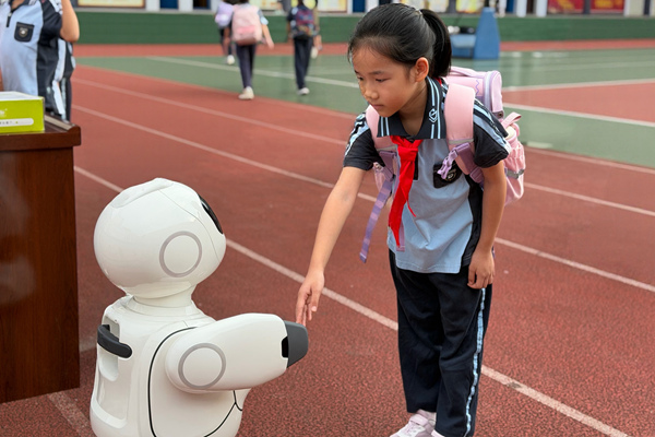智能机器人与入校学生打招呼。学校供图