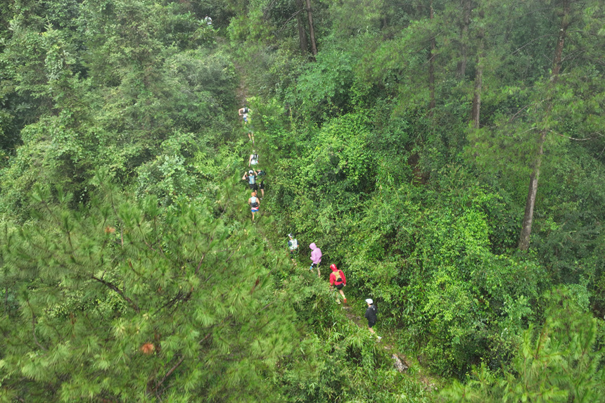 越野线路原始，选手们正在山林中前进。
