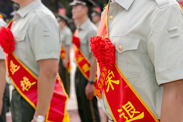 退役士兵整齐佩戴大红花。李章禄摄