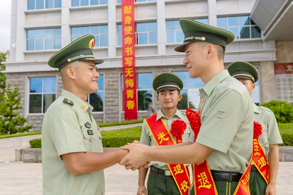 官兵与退役士兵握手话别。杜思念摄