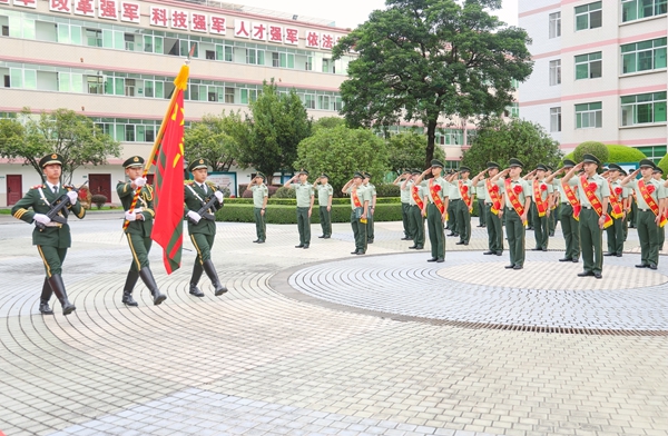 退伍士兵向武警部队旗敬礼。