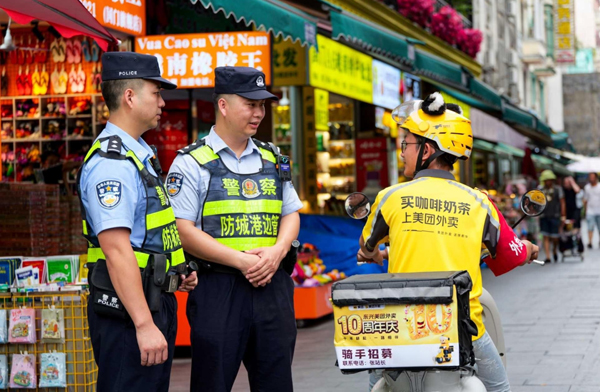 巡邏民警向外賣小哥了解周邊治安狀況。