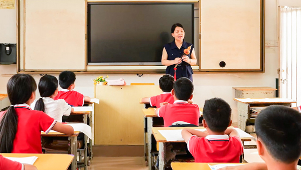 余丽琴带领孩子们学习葫芦丝。北流市教育局供图